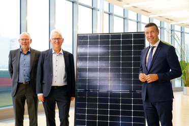 Drei Menschen mit Solarmodul