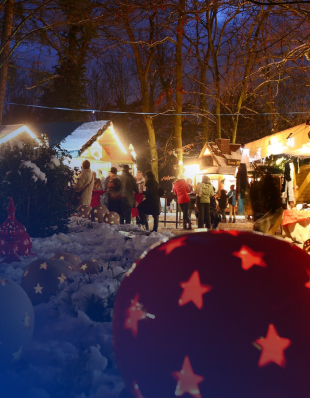 Menschen auf einem Weihnachtsmarkt, beleuchtete Stände