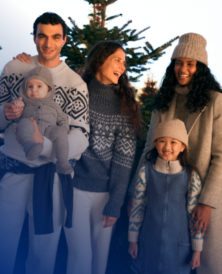 Fröhliche Familie vor einem Weihnachtsbaum, drei Erwachsene mit einem Baby und einem kleines Mädchen