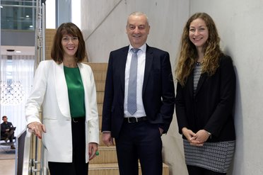 Zwei Frauen und ein Mann stehen auf eine Treppe