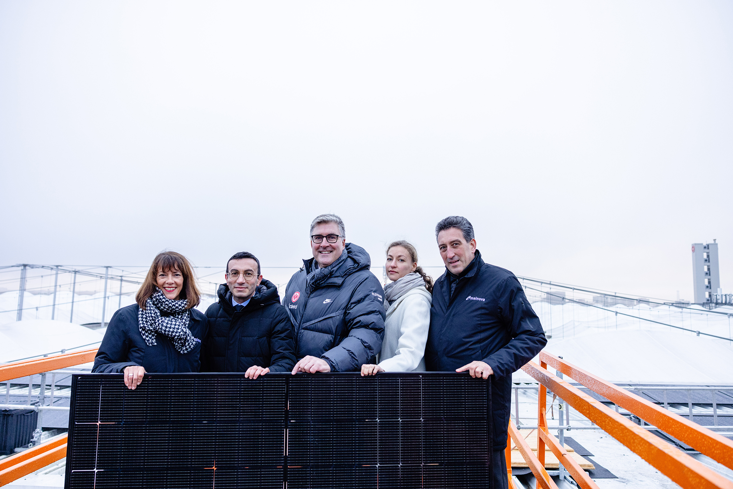 Gruppenfoto mit einem von 1.288 PV-Modulen für den Deutsche Bank Park