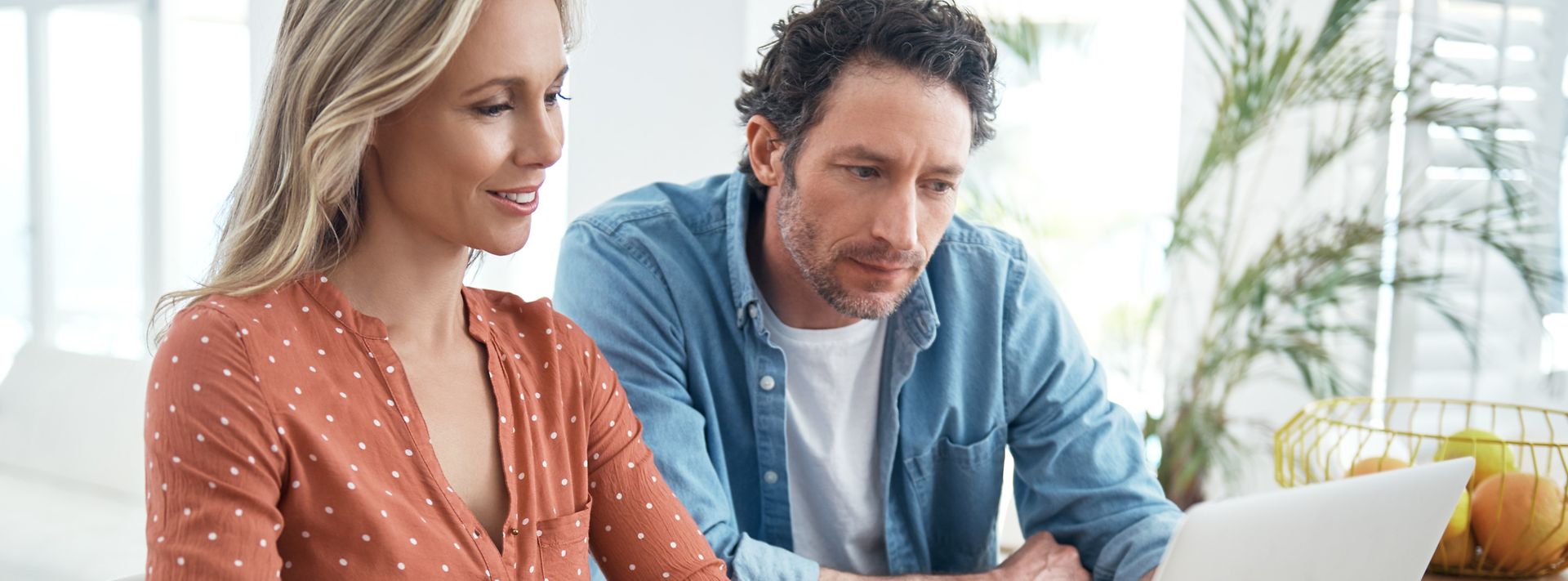 Mann und Frau schauen zu Hause gemeinsam auf Laptop