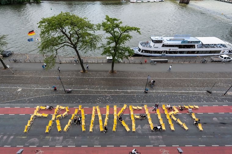 Frankfurter Promenade und dem Schriftzug Frankfurt aus gelben Liegestühlen.