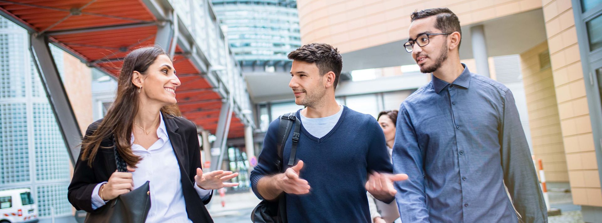 Drei junge Werkstudierende unterhalten sich beim Spaziergang auf dem Gelände der Mainova AG