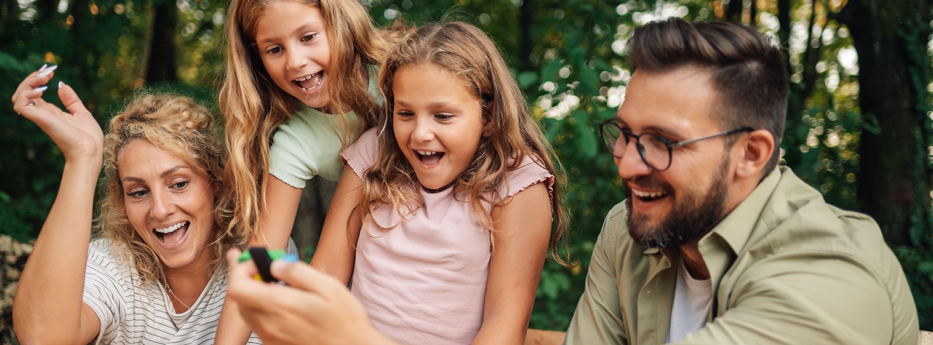 © istock.com/zamrznutitonovi Eine lustige Familie, die mit Holzbausteinen in der Natur spielt